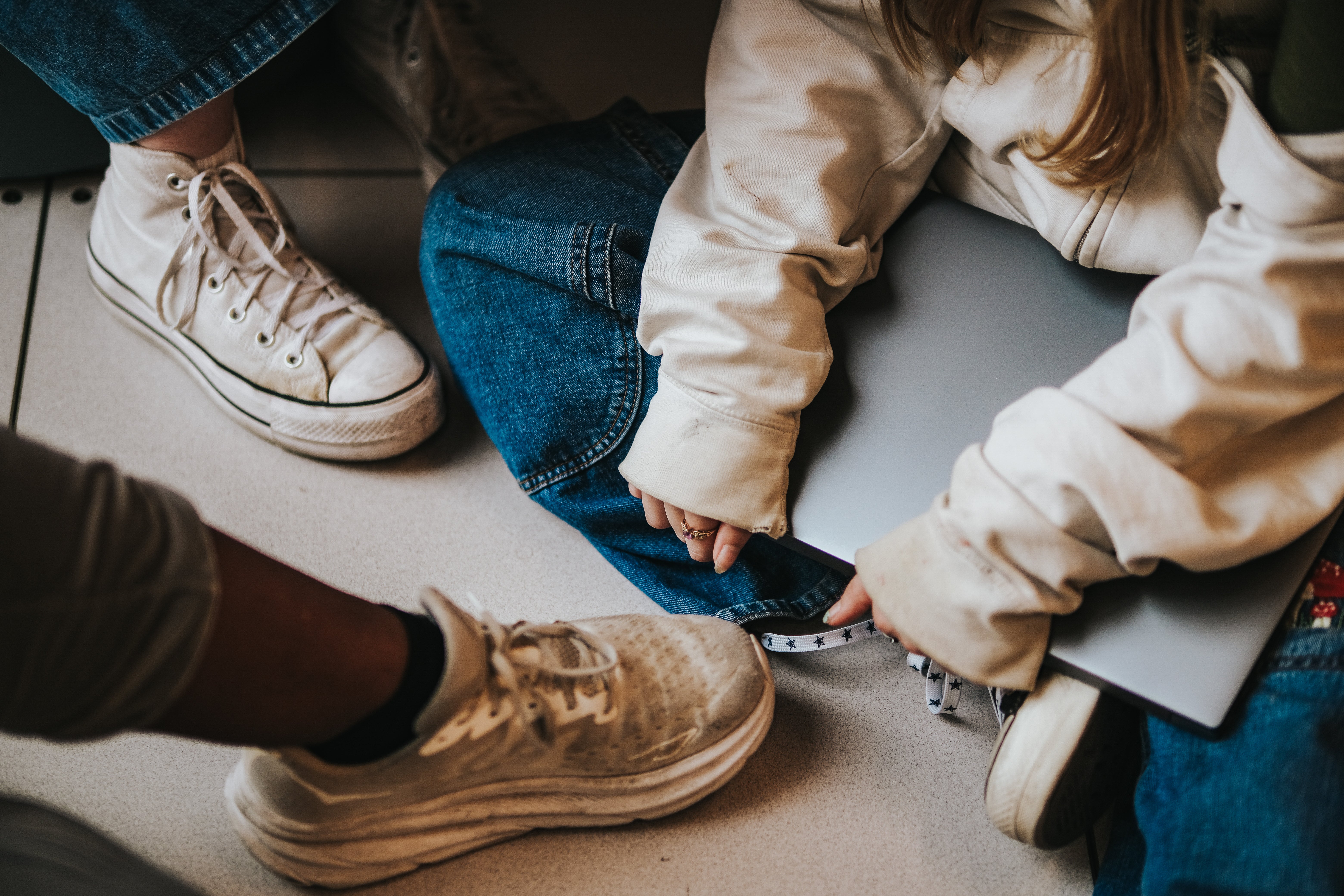 E4Texas students sitting together on the floor, with a focus on their shoes.